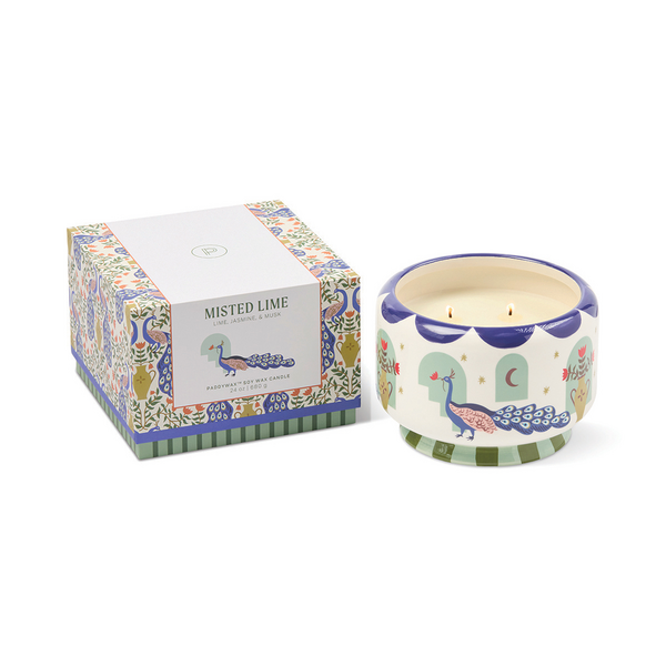 Ceramic candle holder with peacock  design next to peacock decoraged box with 'Misted Lime' label. 