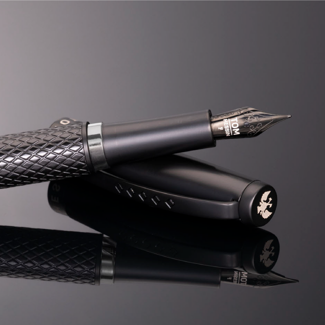 Artful display of the black fountain pen. The pen is resting at an angle on the cap and the image is reflected.