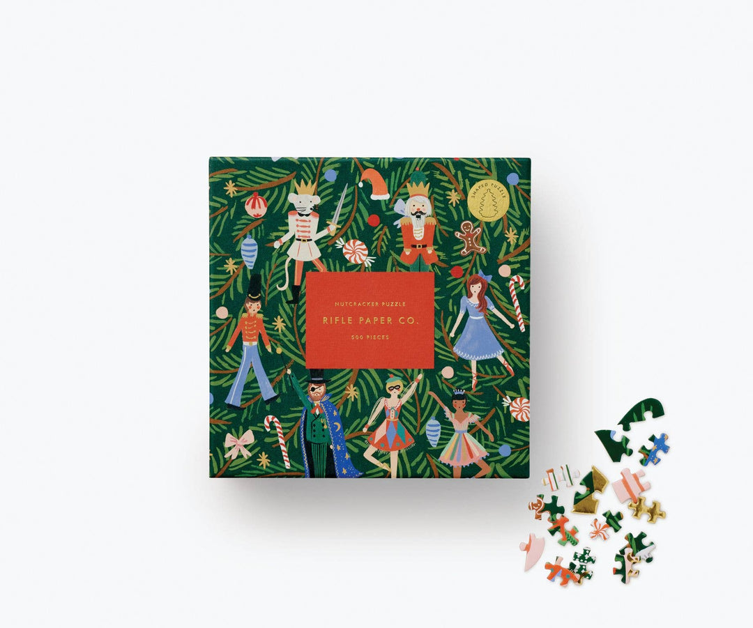 Green puzzle box with characters from the Nutcracker and various Christmas items, such as candy cane, and gingerbread men, and a few puzzle pieces on the side. 