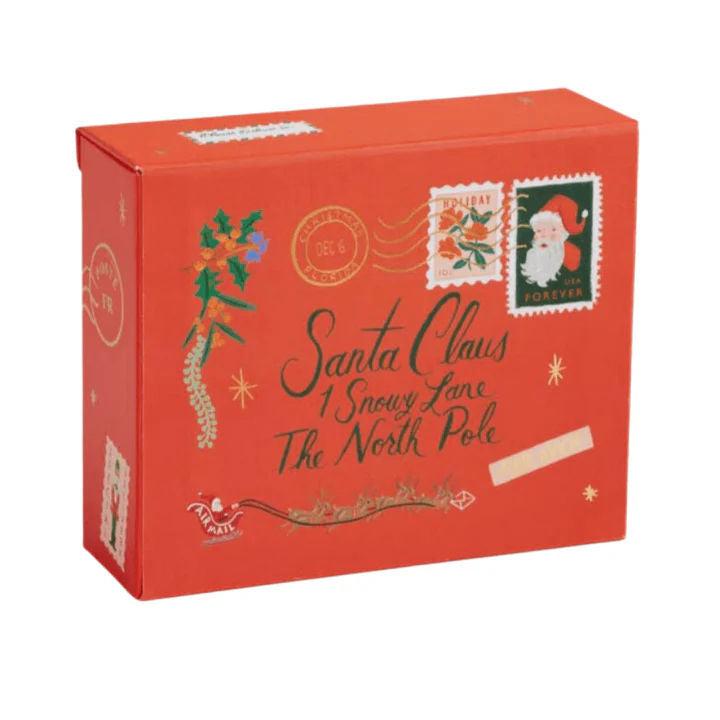 A red Christmas-themed box with festive illustrations, including a Santa Claus postage stamp, holly, stars, and the text 'Santa Claus 1 Snowy Lane The North Pole'.