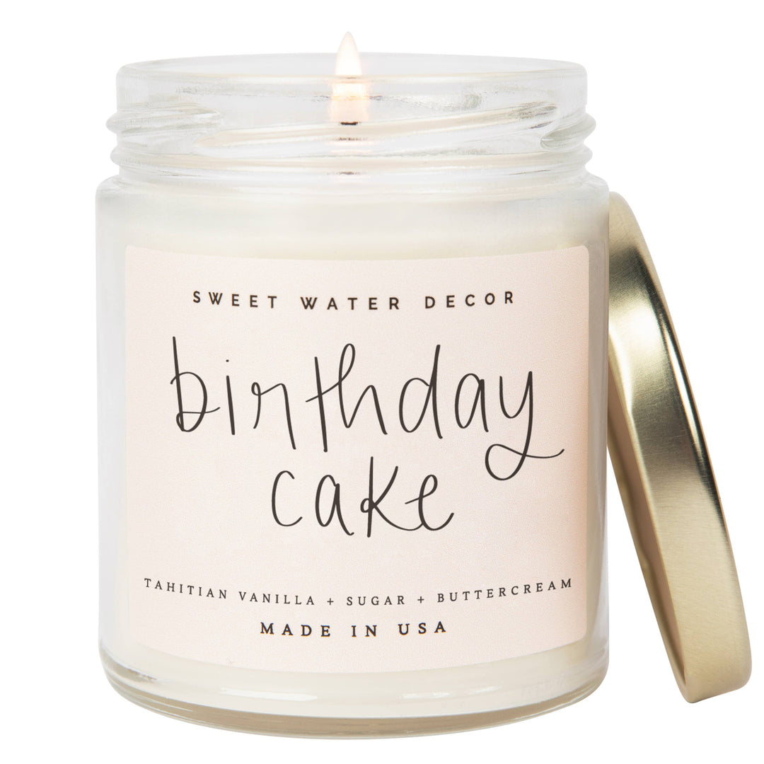 Soy candle in clear glass container with gold tone lid. Text says: Birthday Cake. Tahitian Vanilla, Sugar and Buttercream.