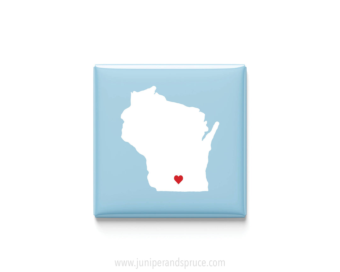 A square light blue magnet featuring a white silhouette of the state of Wisconsin in white with a small red heart near the bottom center.