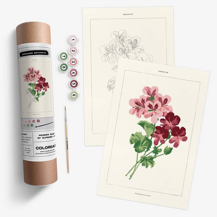 Kit tube, with label showing contents, next to the paint tubes, paintbrushes, and the template and completed painting.