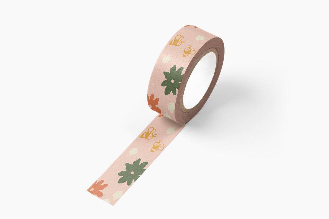 A roll of washi tape with bees and flowers on t.