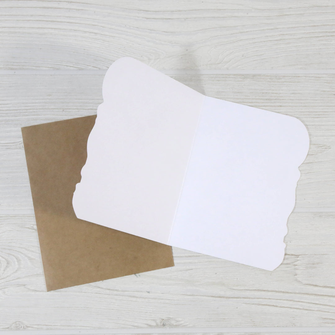 Open blank card showing the die-cut edges next to the kraft envelope.