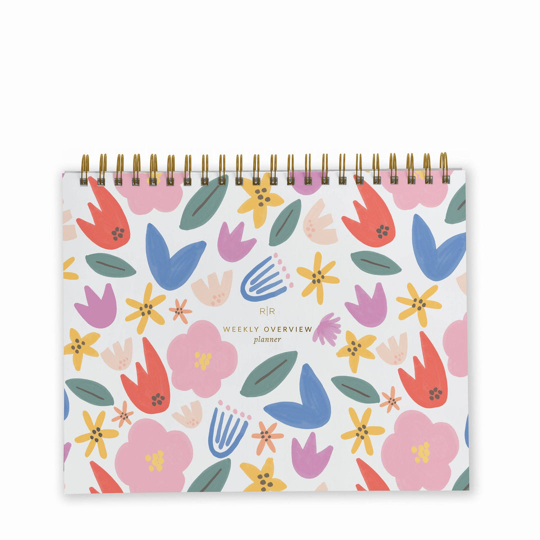 Cover of weekly planner with a pattern of multi-colored flowers and a gold spiral binding at top.