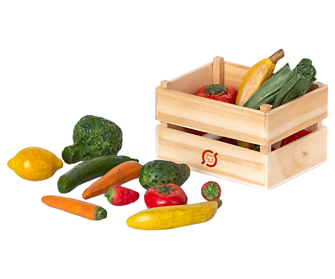 Crate containing vegetables next to its contents: broccoli, lemon, cucumber, carrot, pepper, squash, tomato.