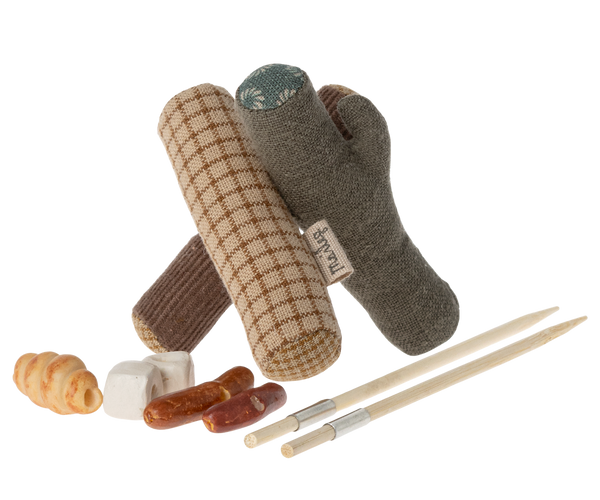 Miniature logs, with little sticks intended for skewering tiny hotdogs, marshmallows or bread.