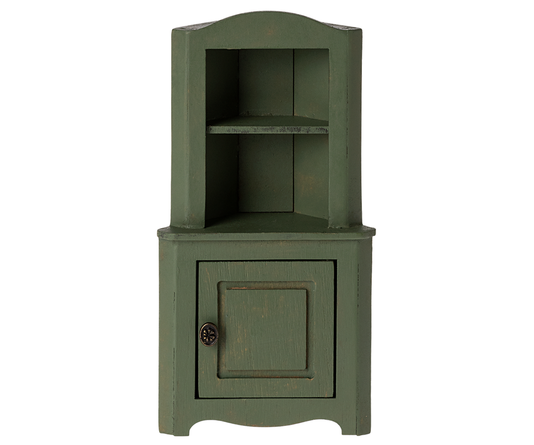 Green corner cabinet with top section with shelf and a door in the bottom section.