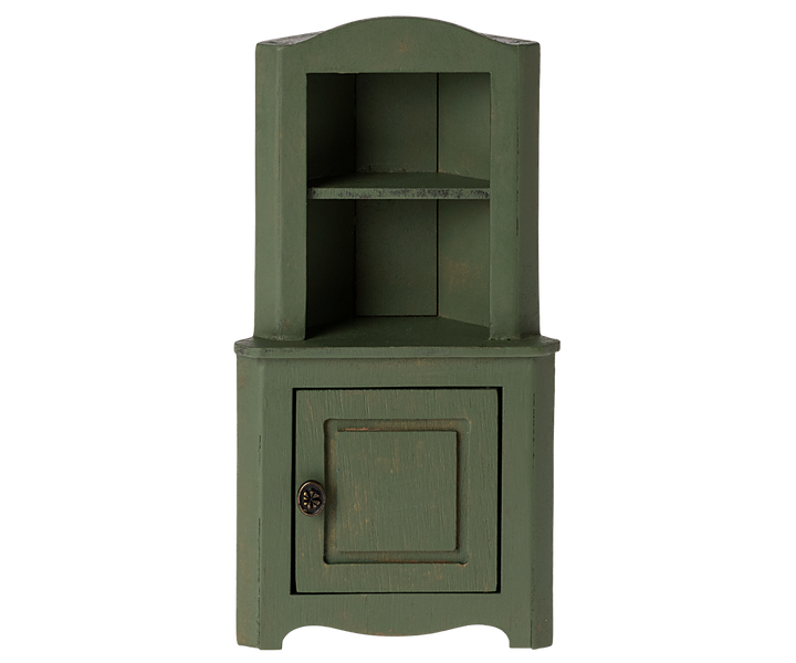 Green corner cabinet with top section with shelf and a door in the bottom section.
