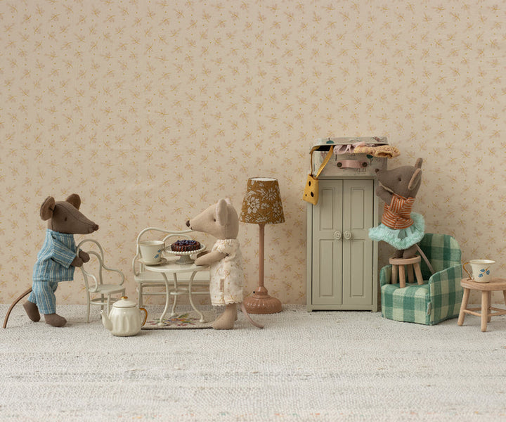 Diorama with mice serving cake on the round table.