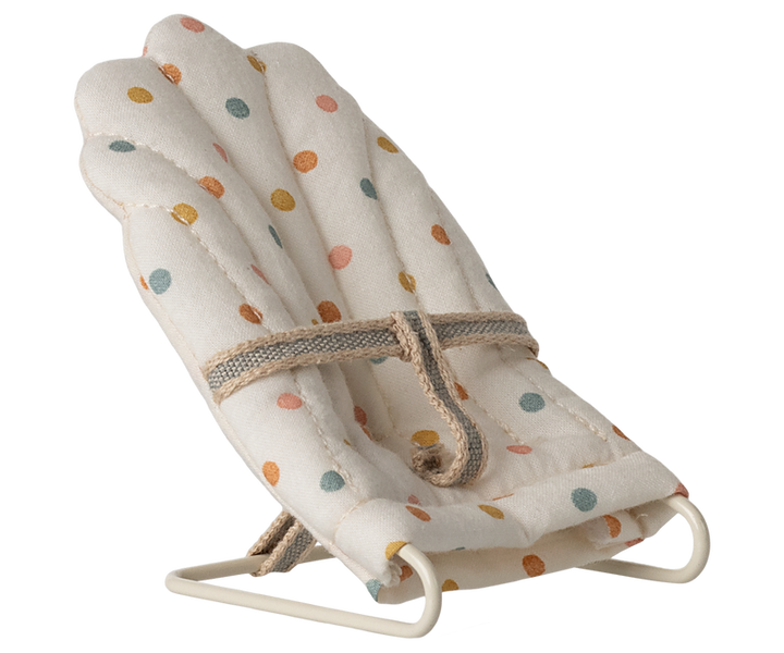 Bouncer chair in a polka dot pattern, nd a brown rope safety belt.