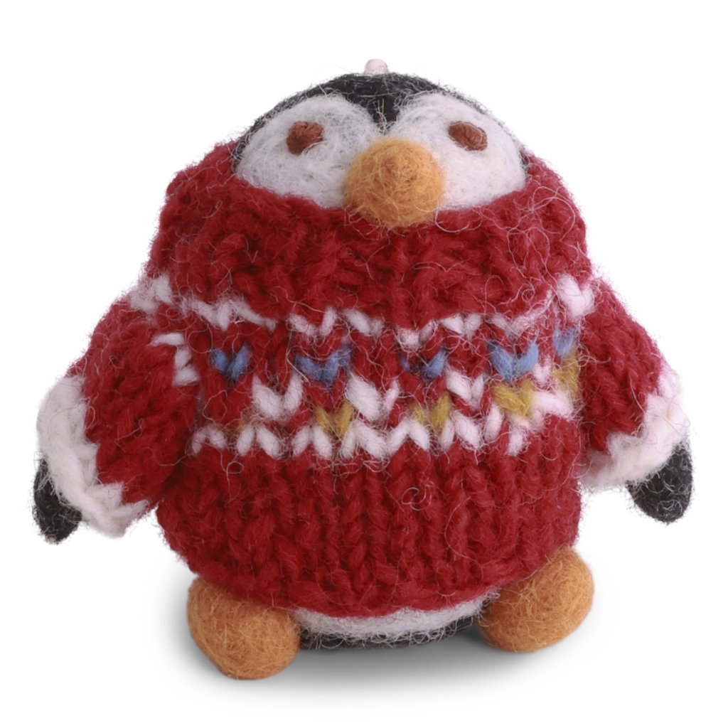 A felt penguin whose head is peaking out of a red knit sweater with a white, blue, and yellow pattern that reaches to its nose.