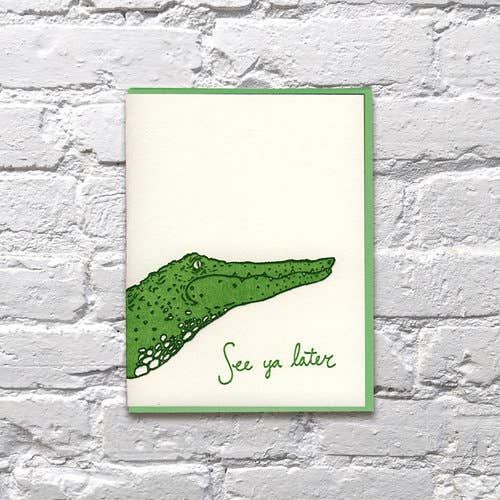 Green drawing of alligator with green cursive text on white cardstock