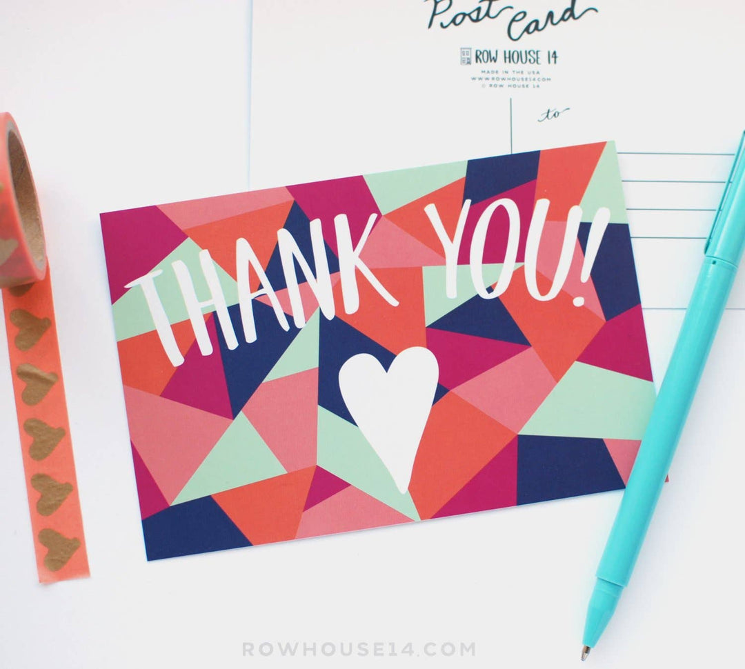 Colorful geometric postcard with 'THANK YOU!' text and a heart, next to a pen and washi tape.