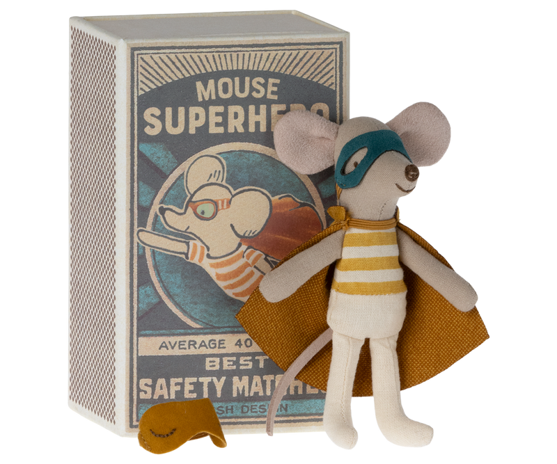 Mouse in dark yellow superhero costume with cape and mask in front of safety matchbox labeled "Mouse Superhero."