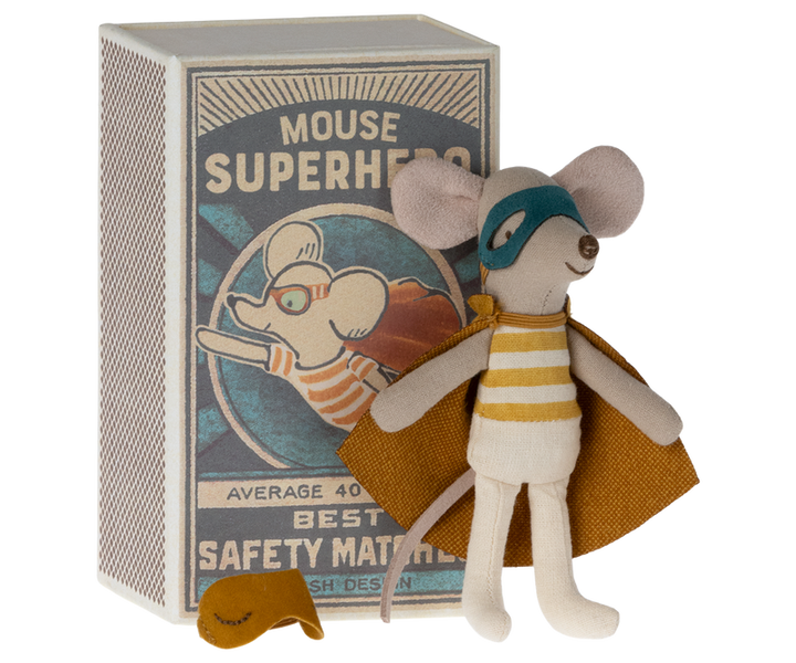 Mouse in dark yellow superhero costume with cape and mask in front of safety matchbox labeled "Mouse Superhero."