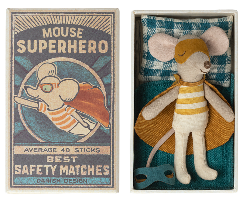 Mouse in dark yellow superhero costume with cape and mask lying in open safety matchbox.