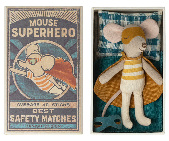 Mouse in dark yellow superhero costume with cape and mask lying in open safety matchbox.