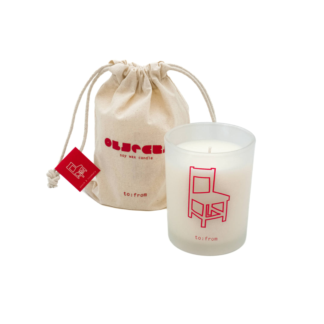 Matte glass printed with the outline of a chair in red, next to a canvas drawstring carrying bag.