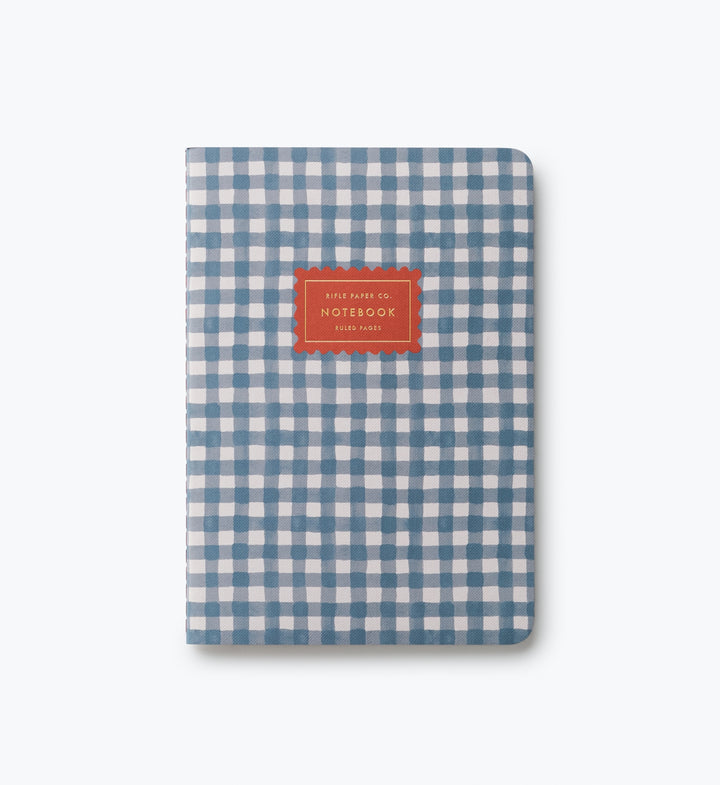 Cover of notebook with blue gingham pager and a red label.