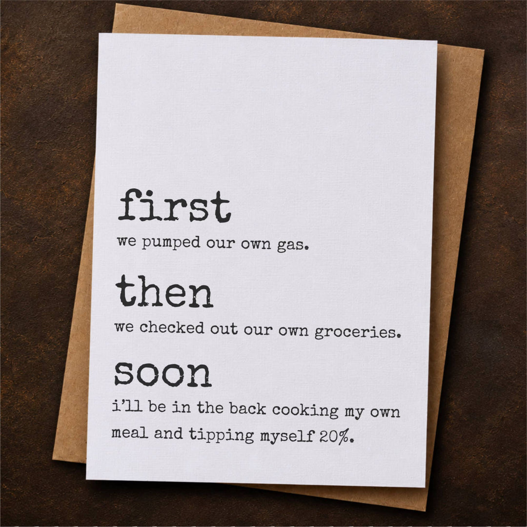 A white greeting card with black printed text reading 'first we pumped our own gas then we checked out our own groceries. soon i'll be in the back cooking my own meal and tipping myself 20%.' and a brown kraft envelope behind it.
