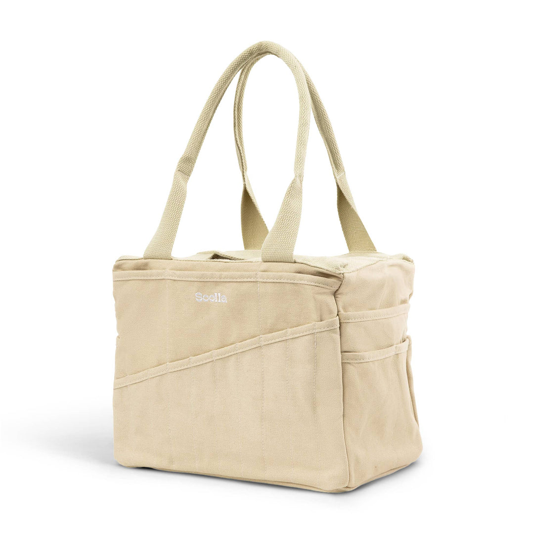 Beige studio bag at an angle, with 10 narrow pockets on the long side and two wider pockets on the end side. 