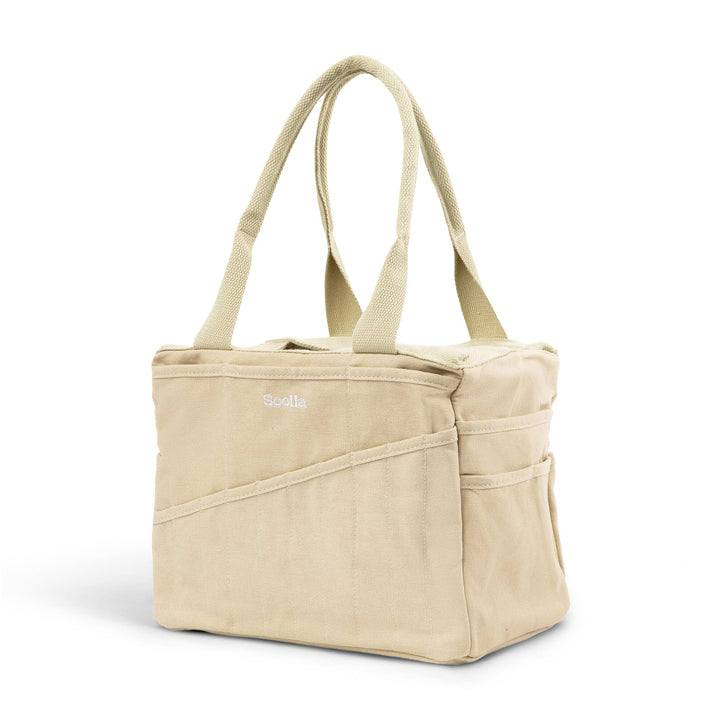 Beige studio bag at an angle, with 10 narrow pockets on the long side and two wider pockets on the end side. 