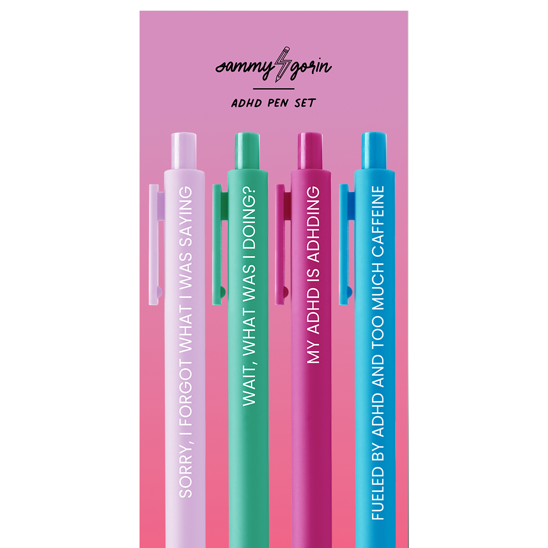 Set of four ADHD-themed pens with colorful packaging on a pink cardboard backing. The colors of the pens are lilac, green, cherry red, and sky blue.