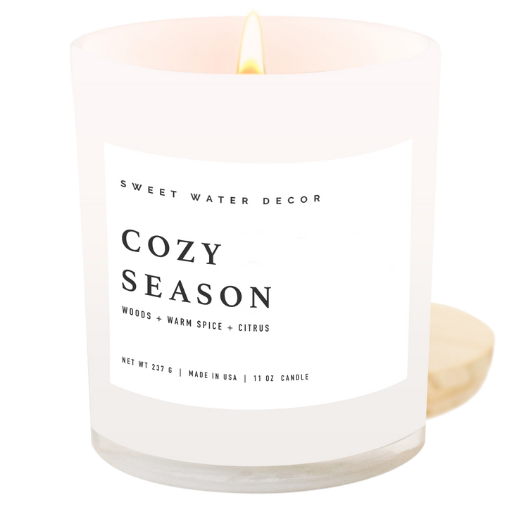 Lighted candle in an opaque jar with 'Cozy Season' label