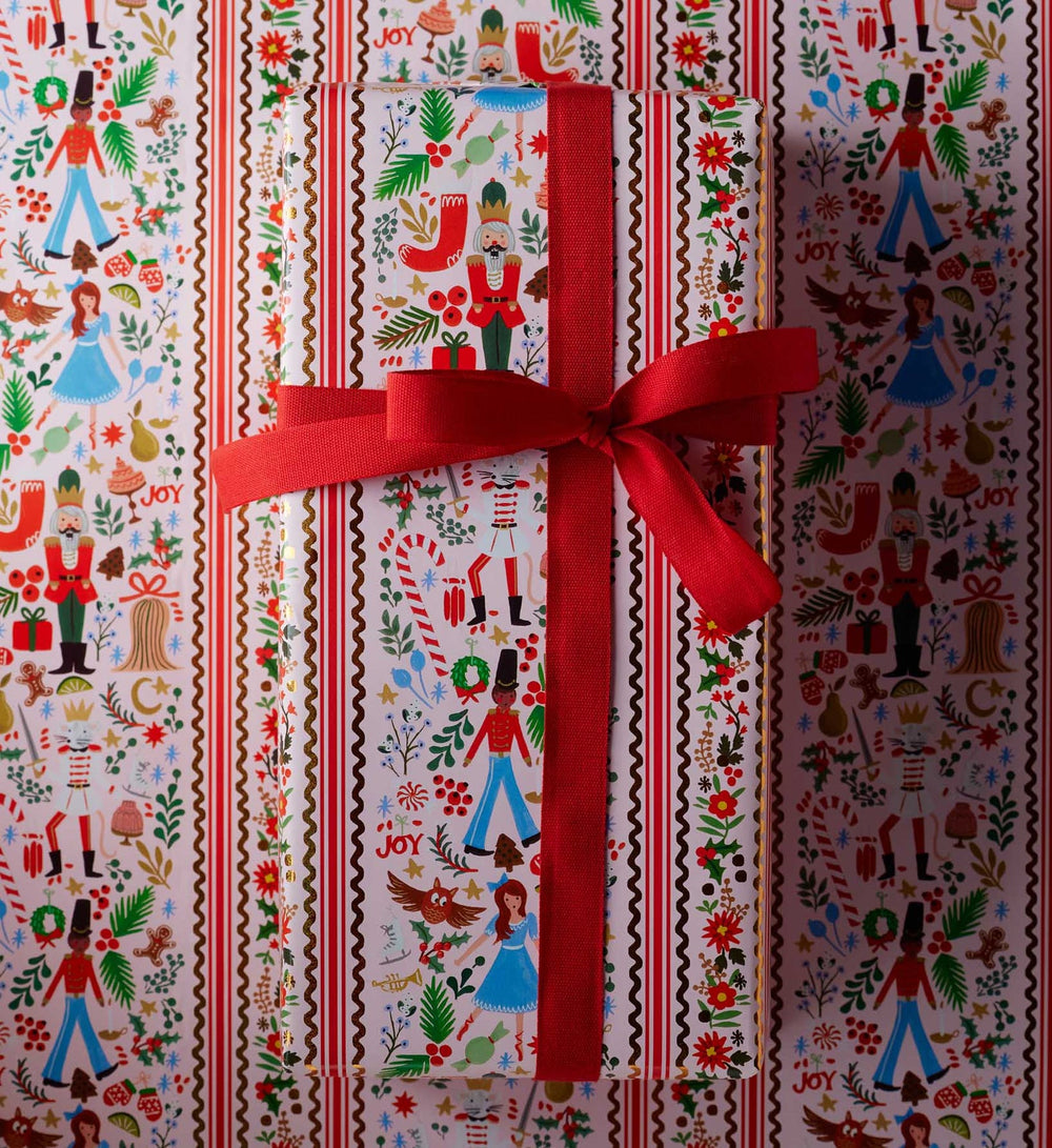 Close up of a wrapped package on top of the Nutcracker-themed paper.
