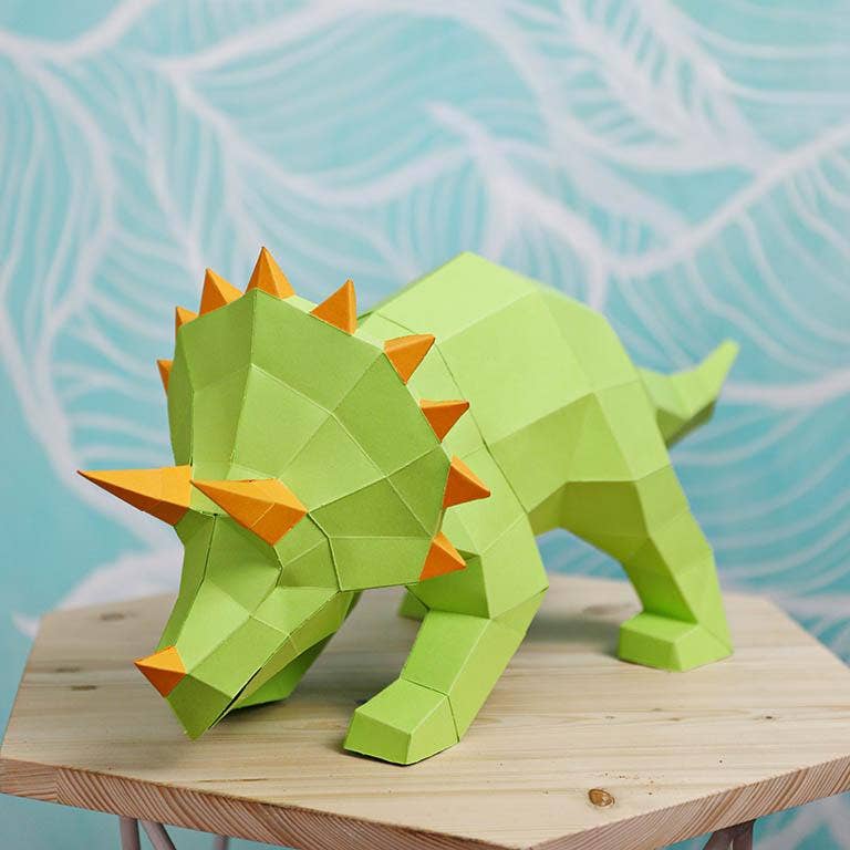 Completed 3D paperboard light green triceratops with orange horns. 