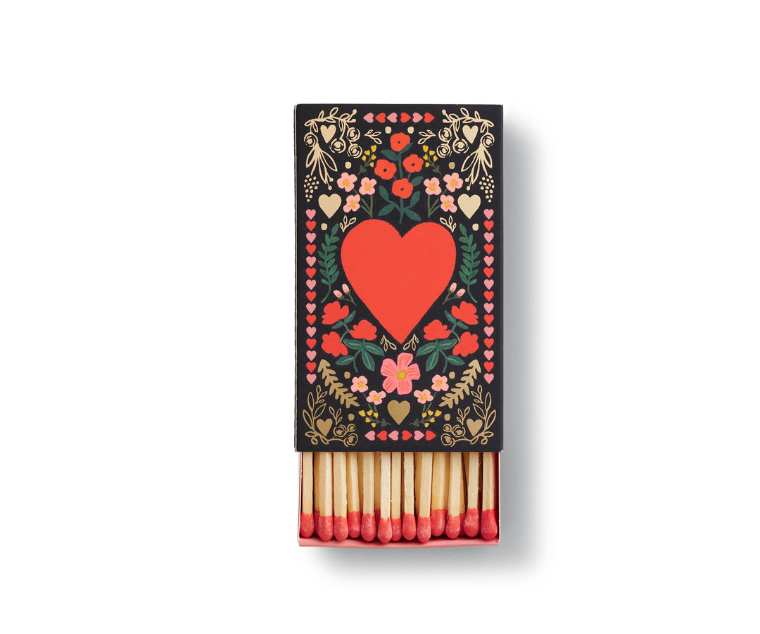 Partially open matchbox with floral design and red heart in the center. 