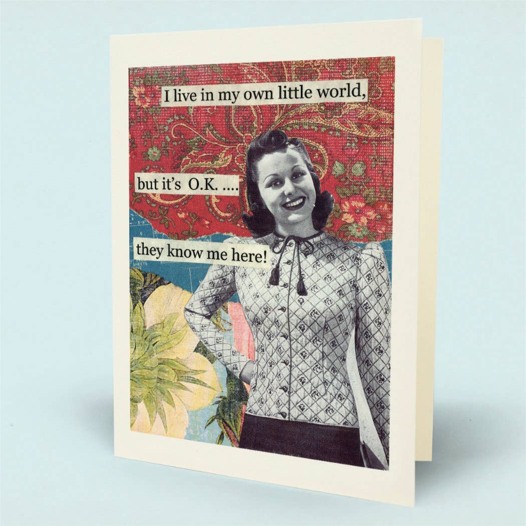A greeting card with a vintage-style collage design, featuring a smiling woman in a patterned blouse against a red floral background with text that reads, 'I live in my own little world, but it's O.K.