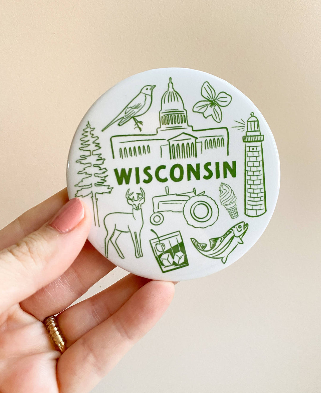 Circular magnet with line drawings of Wisconsin icons and 'Wisconsin' text in green.