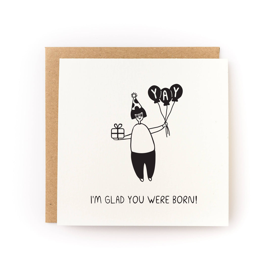 Black and white illustration of a person holding balloons and a gift, with 'YAY' text, and 'I'm glad you were born!' message below.