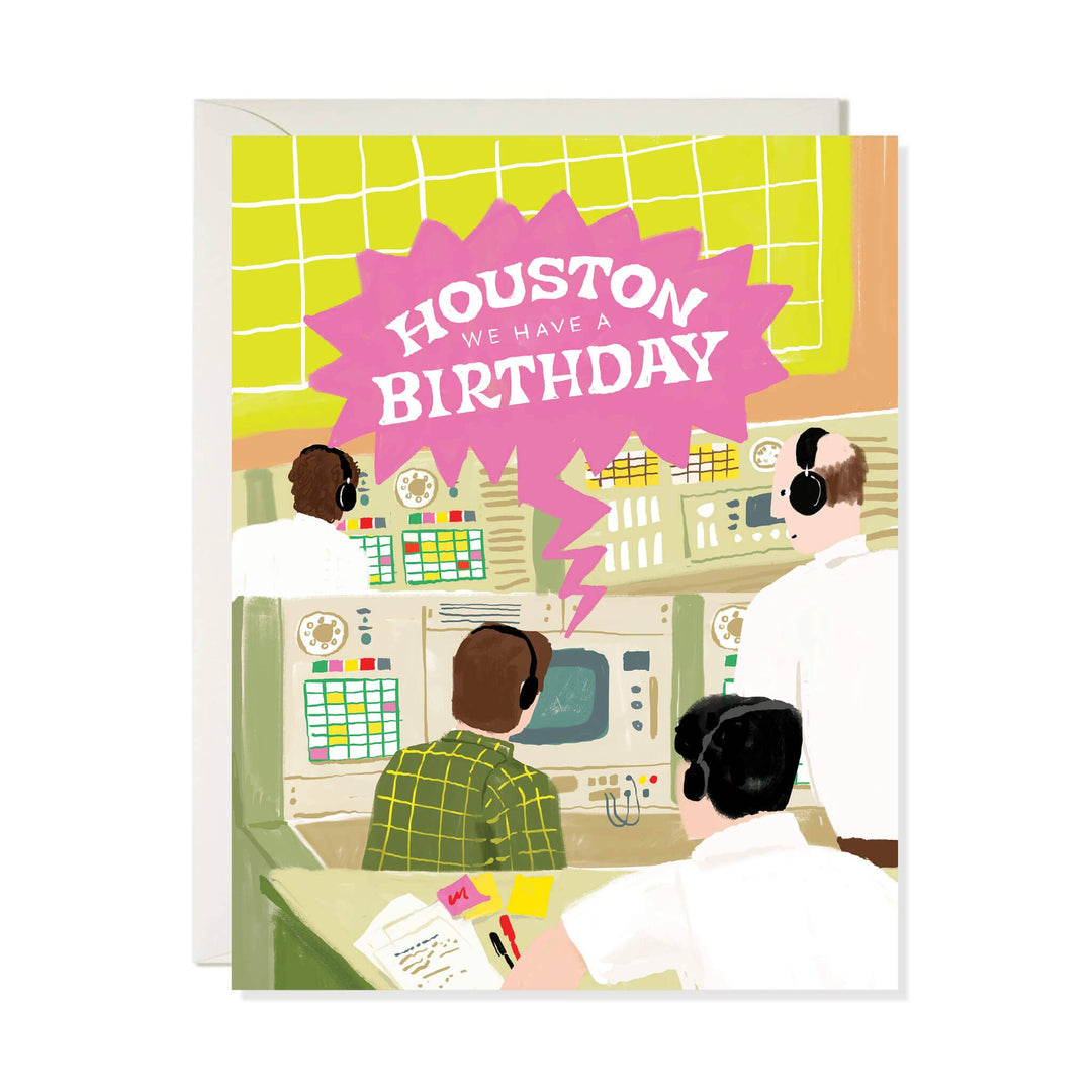 A birthday greeting card featuring an illustrated control room scene with several people wearing headsets at consoles, plus a large pink burst that reads “HOUSTON WE HAVE A BIRTHDAY.” 