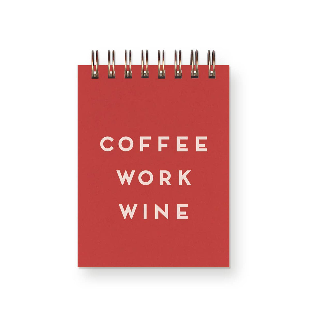 Orange-red notebook with 'COFFEE WORK WINE' text in white an d wire-o binding at the top