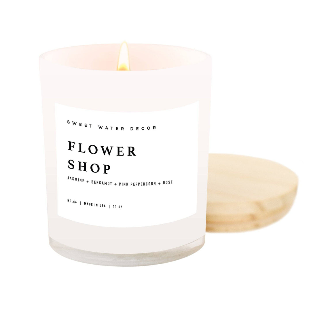 Scented soy candle in a white glass jar with wooden lid. Label is Flower Shop Jasmine / Bergamot / Pink Peppercorn / Rose