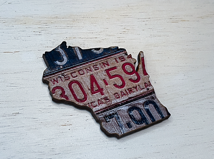 The shape of the state of Wisconsin cut from a vintage license plate.