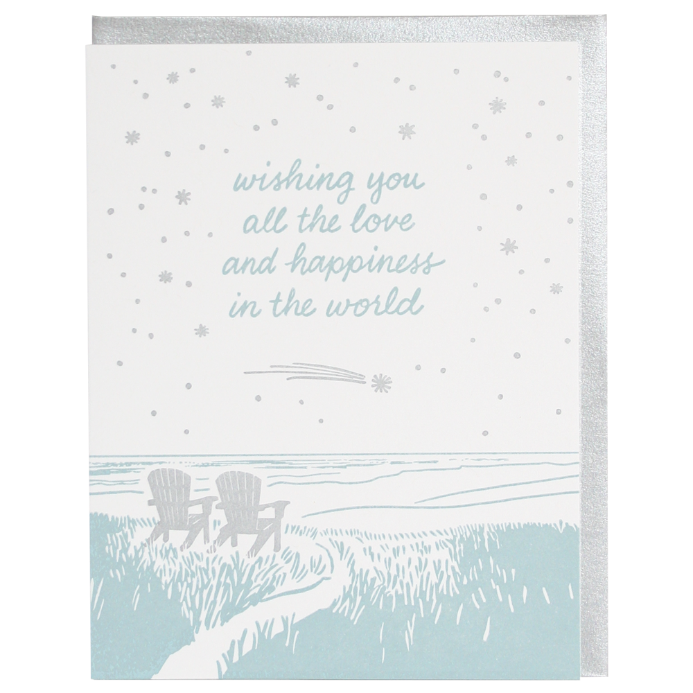 A beach scene with two empty Adirondack chairs facing the ocean below the text 'wishing you all the love and happiness in the world' 
