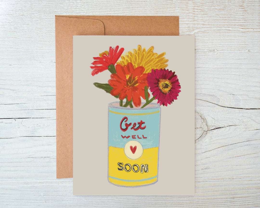 Flowers in reds and yellow in a blue and yellow soup can with the text Get Well Soon.