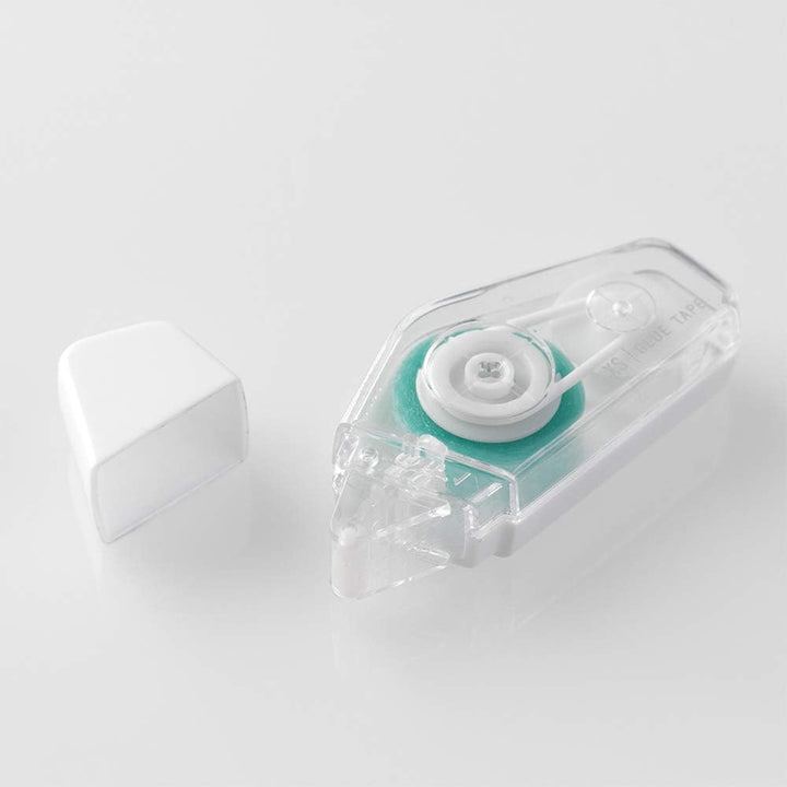 A clear plastic tape dispenser with a white roller and a mint green inner core, shown next to its white cap.