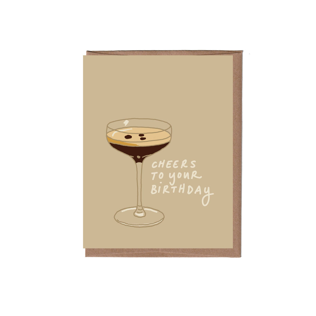 Greeting card with illustration of espresso martini and the script "CHEERS TO YOUR BIRTHDAY" on a light brown background.