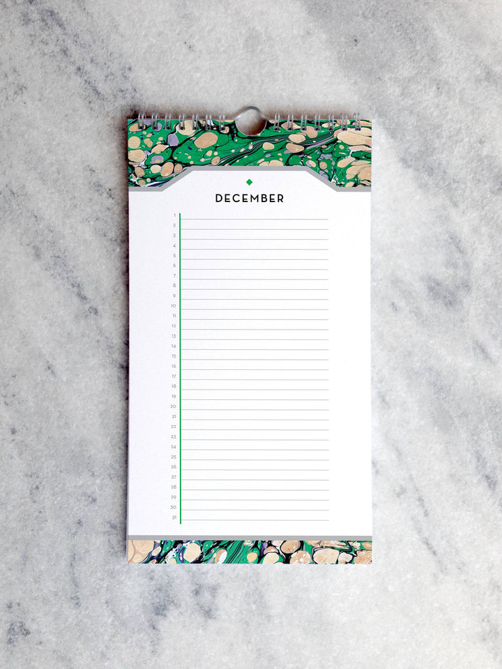 Page for December with marbled paper in shades of green and beige at the top and bottom. Below the month title is a line for each day of the month.