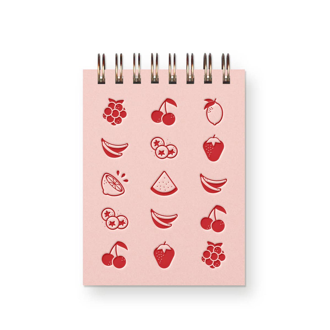 Pink mini spiral-bound notebook with drawings of various fruit on front in red ink