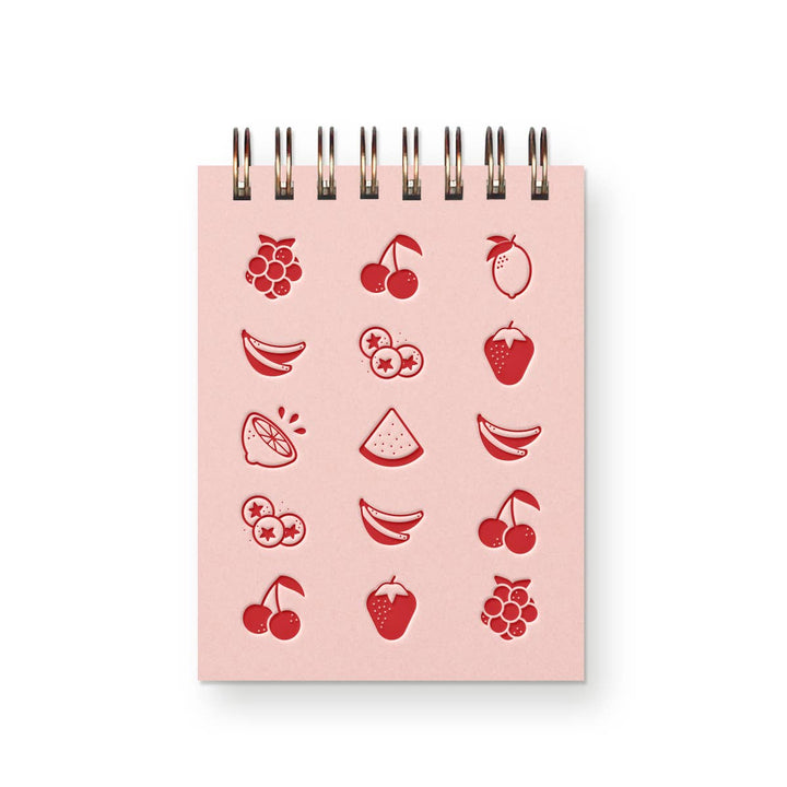 Pink mini spiral-bound notebook with drawings of various fruit on front in red ink