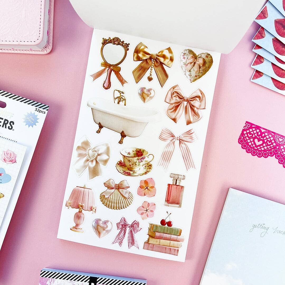 Example page of mostly gold-colored stickers ranging from tea cup to bows to a clawfoot bathtub.