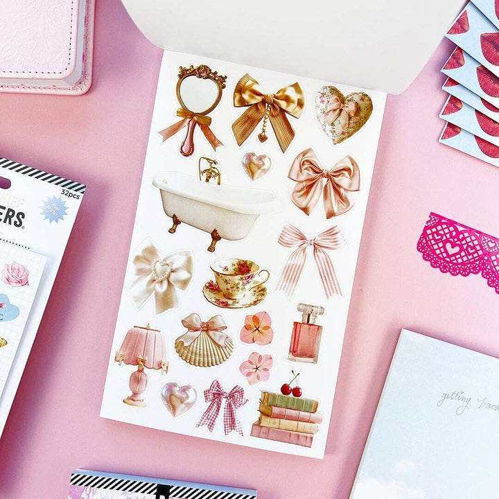 Example page of mostly gold-colored stickers ranging from tea cup to bows to a clawfoot bathtub.
