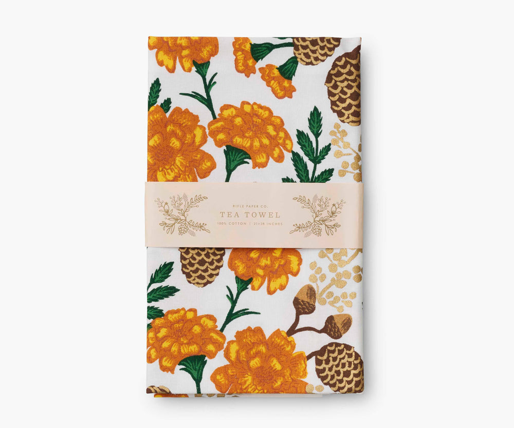 Folded tea towel with orange and brown floral pattern with paper display band.
